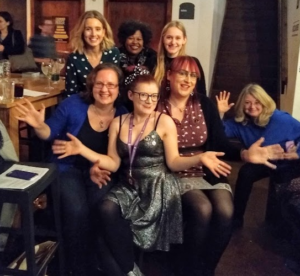 Image of 5 women smiling at the camera in a bar